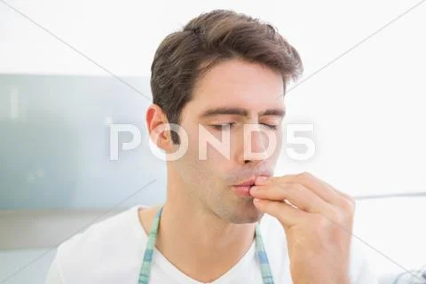 Close up of a young man with eyes closed kissing fingers Stock Photos