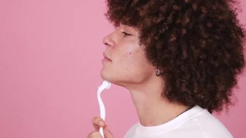 Close-up of a young man with a fluffy afro applying facial cleanser Stock Footage 269362731