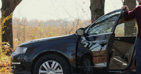 Close up young man gets out of car and opening hood for checking problem of Stock Footage 165147996
