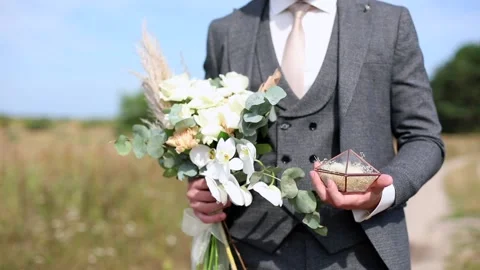 Close-up of young man groom hands holding beautiful white wedding bouquet and 動画素材 143084233