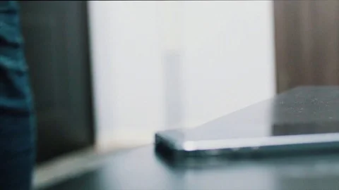 Close up of Young man hand puts mobile phone on wooden desk. Putting down cell Stock Footage 87952452