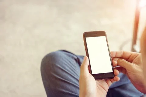 Close up of young man hand using mobile smartphone with blurred background 写真素材