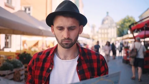 Close up of young man holding a map looking at her looking around serious in the Stock Footage 92072095