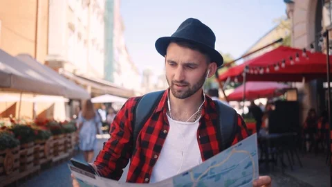 Close up of young man holding a map looking at her speak on phone looking around Stock Footage 92072553