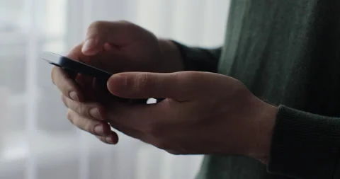 Close up young man holding mobile phone in hands texting message in web chat Video stock 221926109