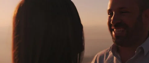 Close up of a young man laughing, looking at his girlfriend with love at suns Stock Footage 136242405