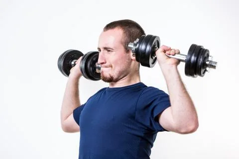 Close up of young man lifting weights over white background Stock-Fotos