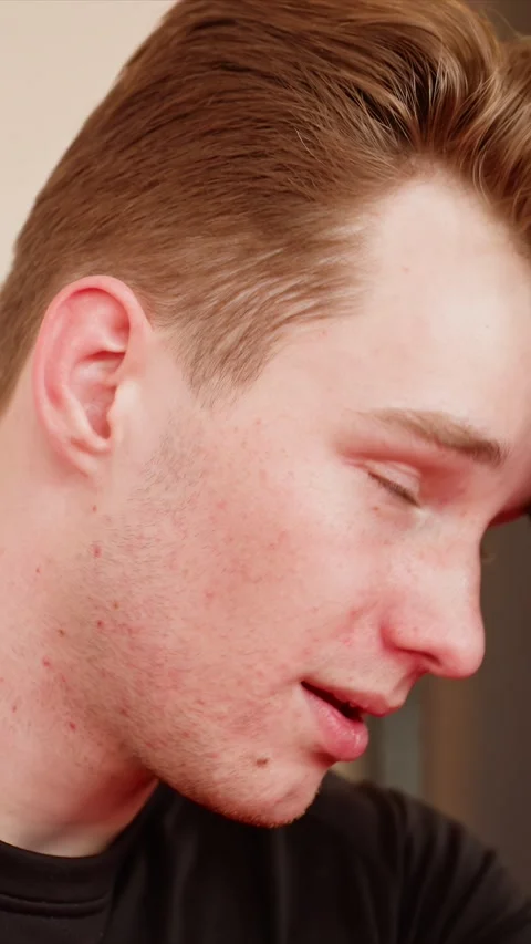 Close up young man with light brown hair freckles neck holding black object Stock Footage 345545796