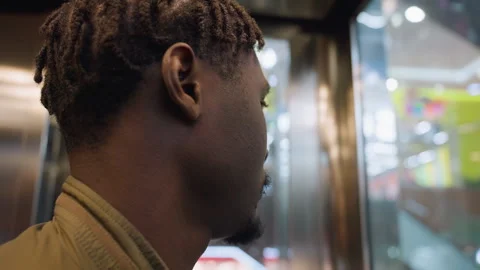 Close Up of Young Man Looking Around Inside Moving Elevator Stockbeeldmateriaal 319920008