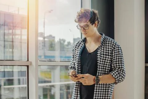 Close up of young man looking at mobile phone screen at metro station. Stock Photos
