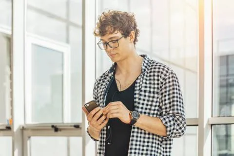 Close up of young man looking at mobile phone screen at metro station. Foto stock