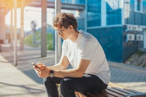 Close up of young man looking at mobile phone screen at metro station. Foto stock