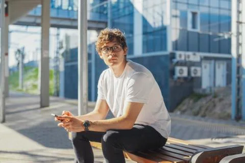 Close up of young man looking at mobile phone screen at metro station. Stock Photos