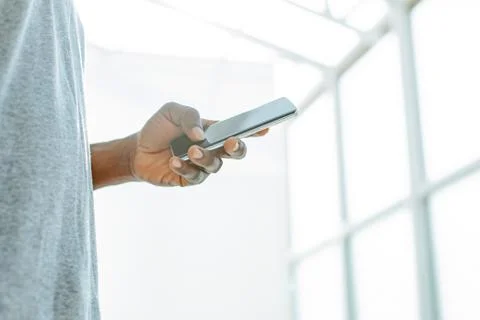 Close up. young man looking at the screen of his smartphone. Stock Photos