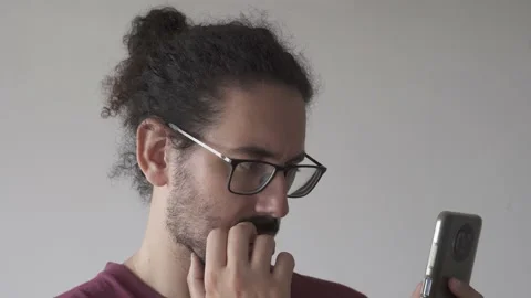 Close up of young man looking at smartphone and biting his nails Stock Footage 161552385