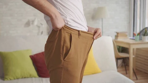 Close up young man lost weight,his trousers became too big for him. Vídeos de archivo 106538842