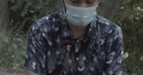 Close up of young man in a mask sanitising hands Stock Footage 136737858