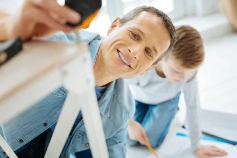 Close up of young man measuring the table leg Stock Photos