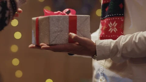 Close-up young man passing a present to his beloved woman on Christmas Eve Video stock 121470915