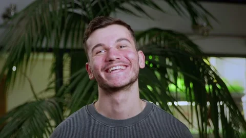Close-up of a young man with pimples on his face. The guy laughs. Problematic Stock Footage 195012464