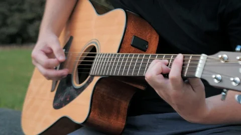 Close up of a young man playing acoustic guitar outside. Hands of a man playing Video stock 113539970