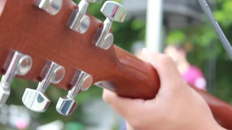 Close-up young man playing guitar on a street Stock Footage 51942813