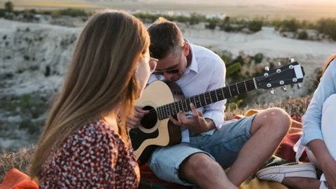 Close up of an young man that is playing at the guitar during the summer picnic  Stock Footage 138740565