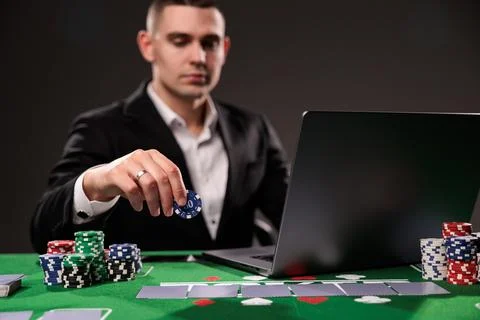 Close-up of young man playing roulette. Lucky guy bets at online casino at ho Stock Photos
