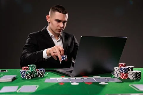 Close-up of young man playing roulette. Lucky guy bets at online casino at ho Stock Photos