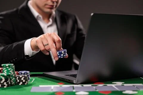 Close-up of young man playing roulette. Lucky guy bets at online casino at ho Stock Photos