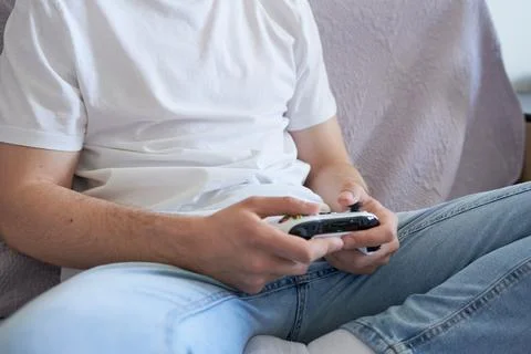 Close-up of a young man playing video games on a console. Stock Photos