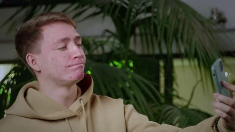 A close-up of a young man with problematic skin taking a selfie on his Stock Footage 205296842