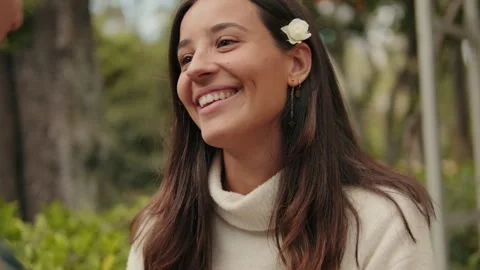 Close up young man putting flower behind his girlfriend's ear Stock Footage 302114472