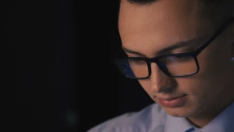 Close up of young man reading his tablet in the dark. dark background. Stock Footage 96491875