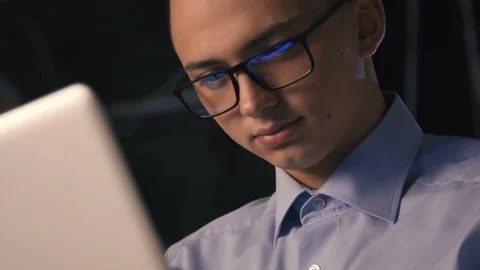 Close up of young man reading his tablet in the dark. dark background. Stock Footage