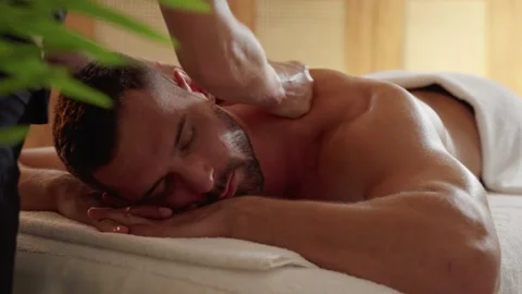 Close-up on a young man receiving a professional back massage Stock Footage 165942893