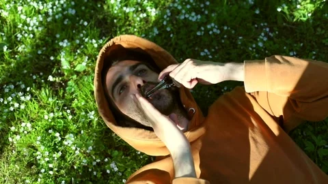 Close-up of young man resting on forest flowers grass playing on vargan Видео 154400596
