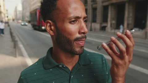 Close up,young man sends voice message on cellphone while standing on the street Stock Footage 227091913