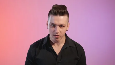 Close-up of young man singing with red and violet lights at background in studio Video stock 114290945