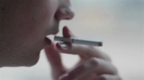 Close-up of a young man smoking a cigarette Stock Footage 49858338