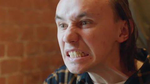 Close up of young man speaking calmly in indoor setting with soft lighting and Stock Footage 344874425