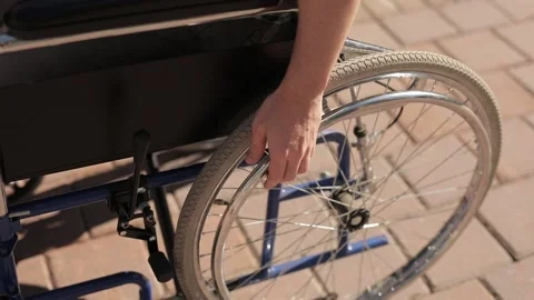 Close Up, young man steering the wheel of the wheelchair. Stock Footage 147378451