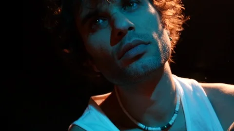 Close-up young man in studio with hot and cold neon light Stock Footage 126862100