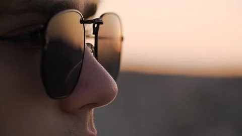 Close up of a young man in sunglasses looking at the view at the sunset Stock Footage 142550027