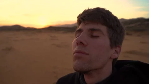 Close-up of a young man taking deep breaths in meditation concept with his ey Stock Footage 218255015