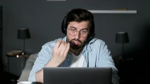 Close-up of a Young Man Talking Online Swearing, Angry Looking at the Computer Stock Footage 144375780