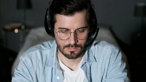 Close-up of a Young Man Thinking Looking at a Computer, Using a Laptop Stock Footage 144378218