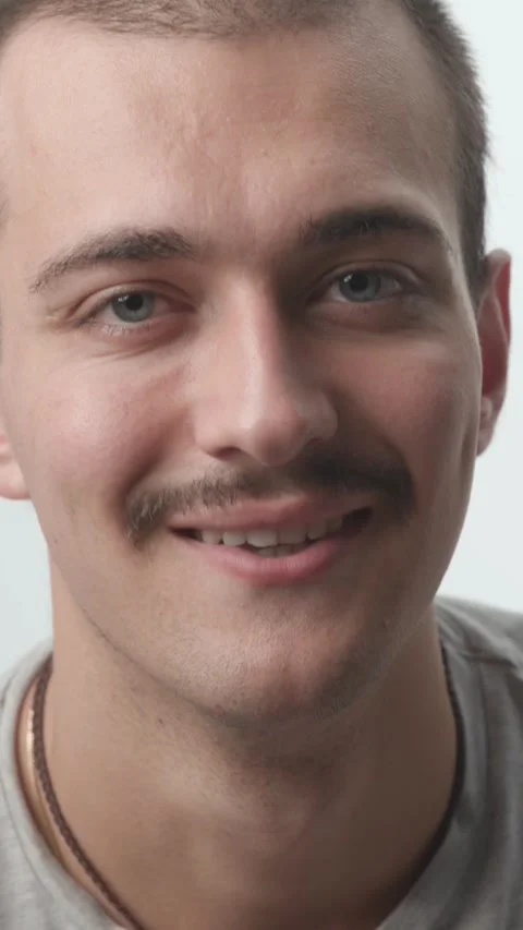 Close-up of Young Man Turning Serious Face into Smile on White Background Stock Footage 341659453
