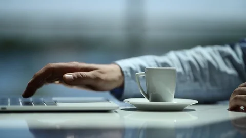 Close-up of a young man typing on a laptop sipping an espresso at the office Stock Footage 90320460
