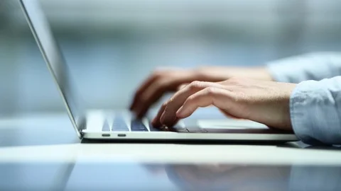 Close-up of a young man typing on a laptop at the office Stock Footage 90395192